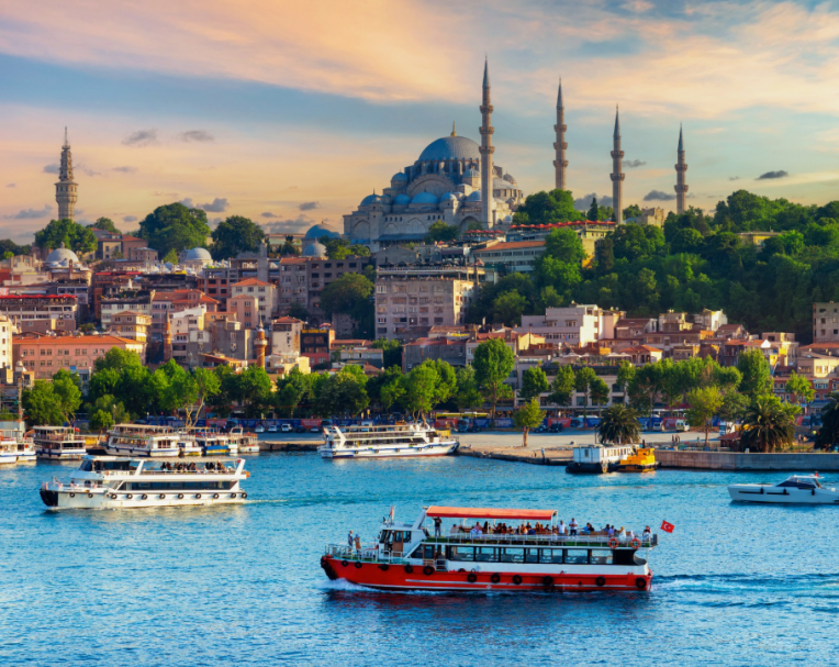 View of Istanbul's skyline with boats on the Bosphorus and the Blue Mosque in the background.